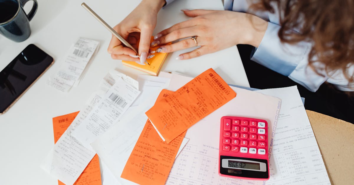 Travel receipts, camera, and laptop arranged for content business records.